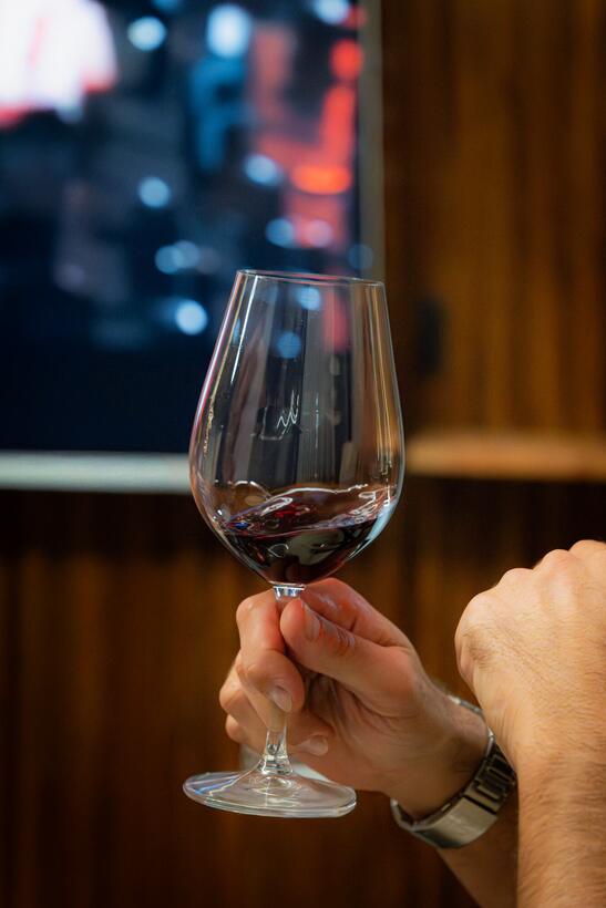 Una mano sostiene una copa de vino tinto