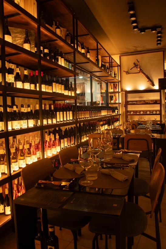 Salón con mesas y estantes altos de botellas